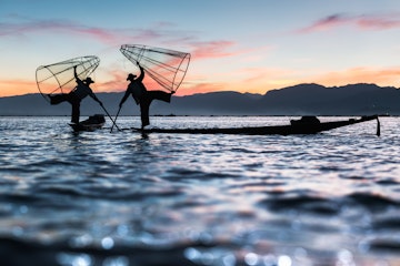 Two Intha fishermen pose during sunset