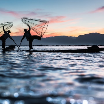 Two Intha fishermen pose during sunset
