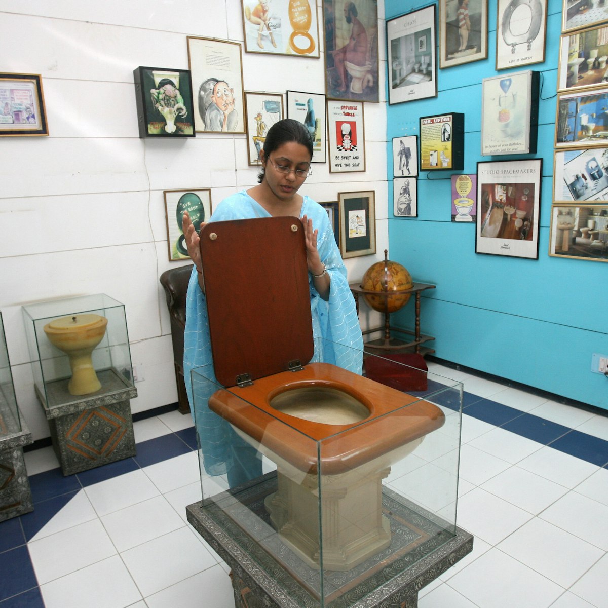 TO GO WITH STORY BY TRIPTI LAHIRI  An employee of the Sulabh International Museum of Toilets displays a Fancy Toilet used in the 1930s at the museum in New Delhi, 27 October 2007.   For India's low-cost toilet champion, each new loo means freedom not just from rampant disease, but one more chance to liberate someone from doing the awful job of disposing of someone else's waste. In the centuries-old caste system, with its ingrained fear of "pollution," the deepest revulsion has traditionally been reserved for those who do India's dirty work, such as taking away human waste from homes in buckets. AFP PHOTO/RAVEENDRAN (Photo credit should read RAVEENDRAN/AFP/Getty Images)