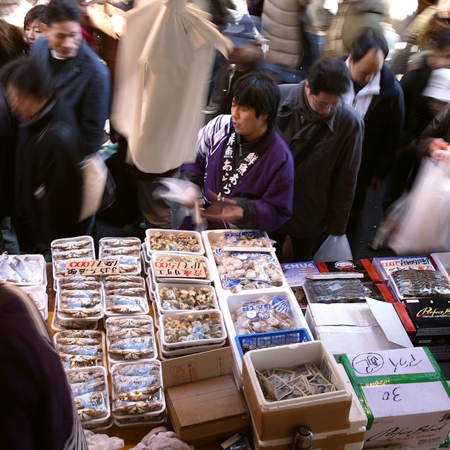 TOKYO - DECEMBER 31: A fishmonger sells seafood at a fish stall in the Ameya Yokocho street market on December 31, 2008 in Tokyo, Japan. People shop around in preparation to celebrate the New Year holidays at the market featuring over 500 stalls, which sell various products such as fresh fish, dried food, vegetables, fruits, spices, clothes, bags and cosmetics on the narrow street. (Photo by Kiyoshi Ota/Getty Images)
