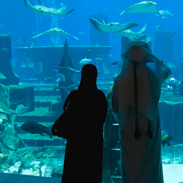 Local couple viewing marine life at Lost Chambers, Atlantis Hotel, Dubai, United Arab Emirates