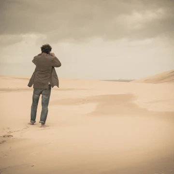 Australia, New South Wales, Woromi Conservation Lands, barefoot man taking photo in desert
