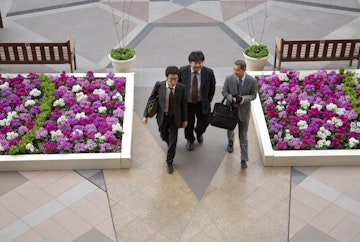 Businessmen passing flowerbeds, Yebisu Garden Place, Ebisu.