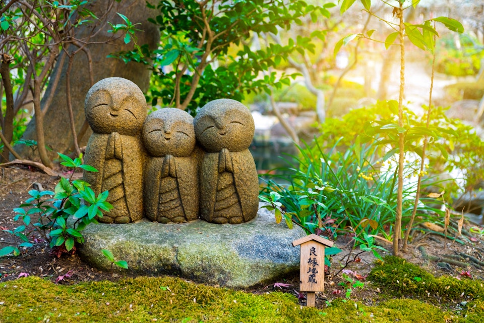 Small smiling stone buddha monk statue (Nagomi Jizo). The Japanese characters mean "The Jizo for good relationship". Hasedera Temple, Kamakura, Japan; Shutterstock ID 539525365; Your name (First / Last): Laura Crawford; GL account no.: 65050; Netsuite department name: Online Editorial; Full Product or Project name including edition: BiA: Takayama, south of Tokyo POI images for online