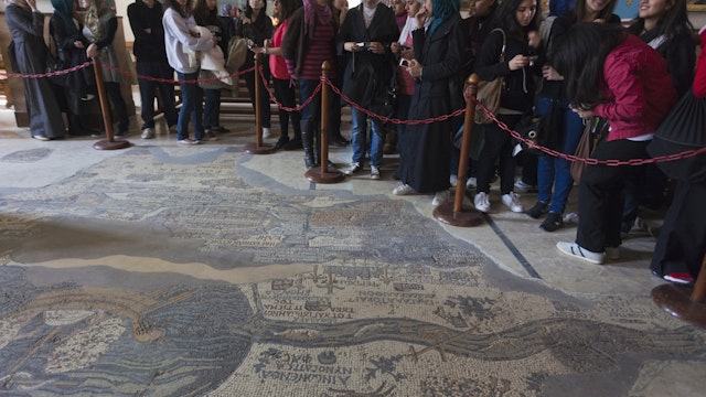 Interior with ancient Mosaic Map of World, circa 560 AD with visitors, St. Georges Church, Madaba, Kings Highway, Jordan