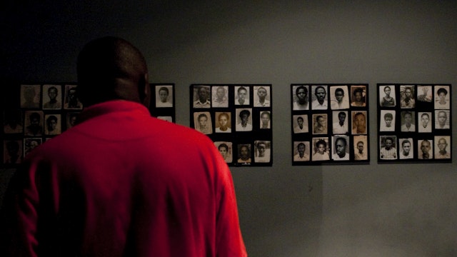 Man viewing photos of victms of genocide at Kigali Memorial Centre.