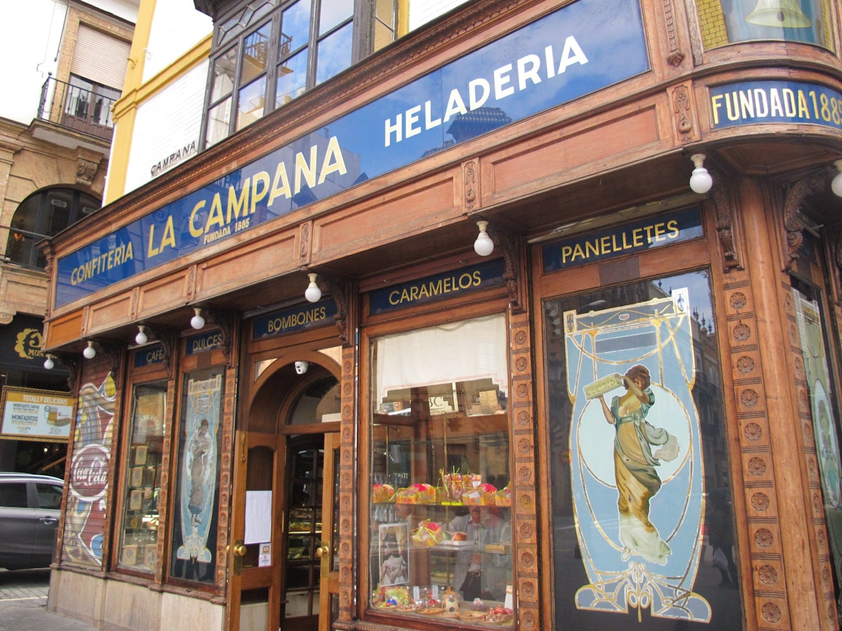 Facade of shop with name, pictures and produce displayed in window, Confiteria La Campana.