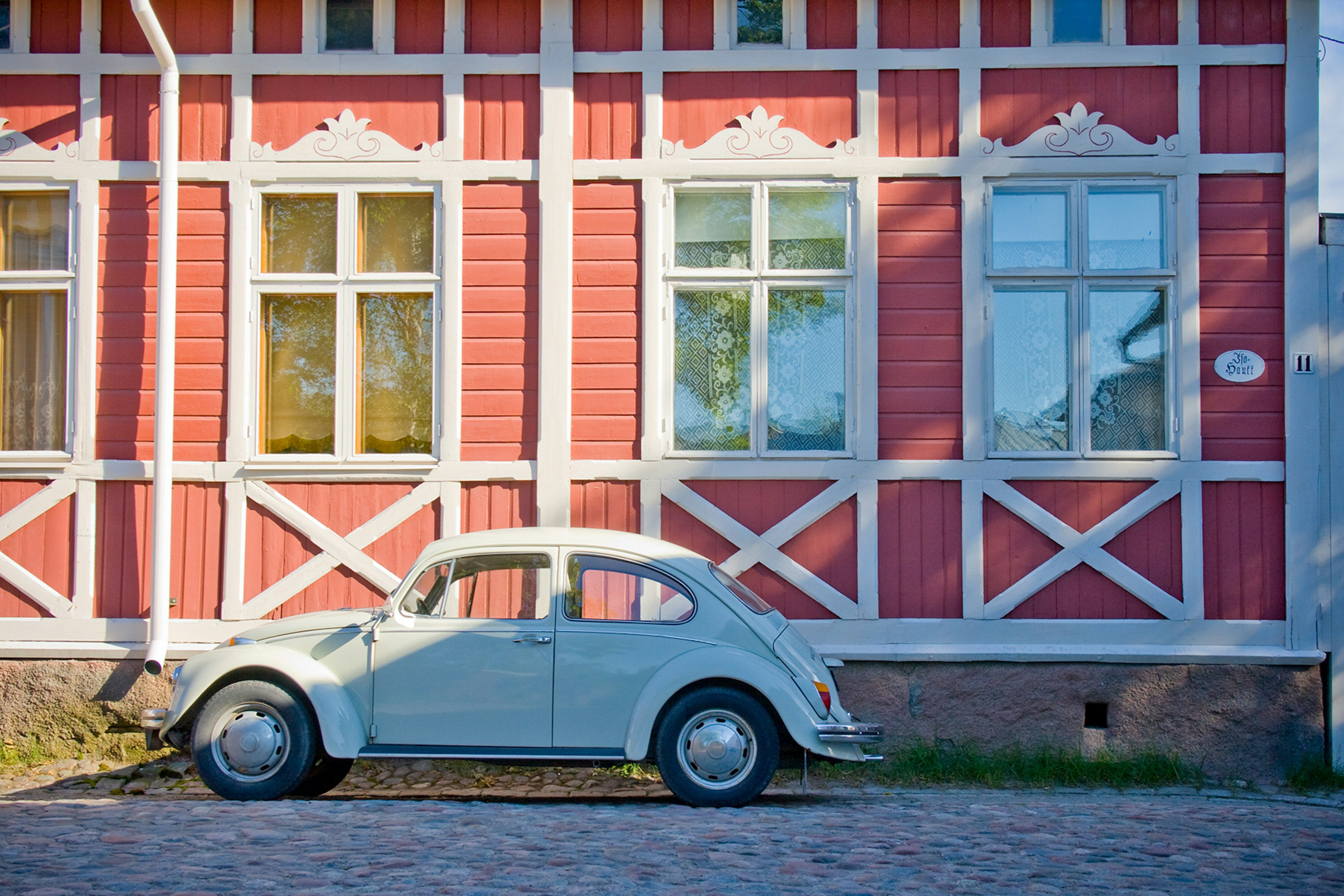 Old car is parked in front of old wooden house in Rauma, Finland, which is a UNESCO World Heritage site