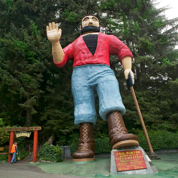 Paul Bunyan in parking lot at the Mystery of Trees. 42 feet tall. Woman at entrance gives a perspective to the size.