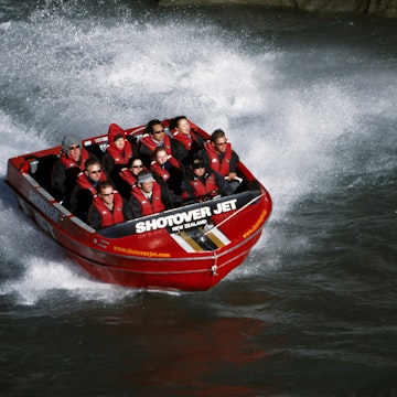 New Zealand, South Island, Queenstown. Tourists ride the Shotover Jet on the Shotover River