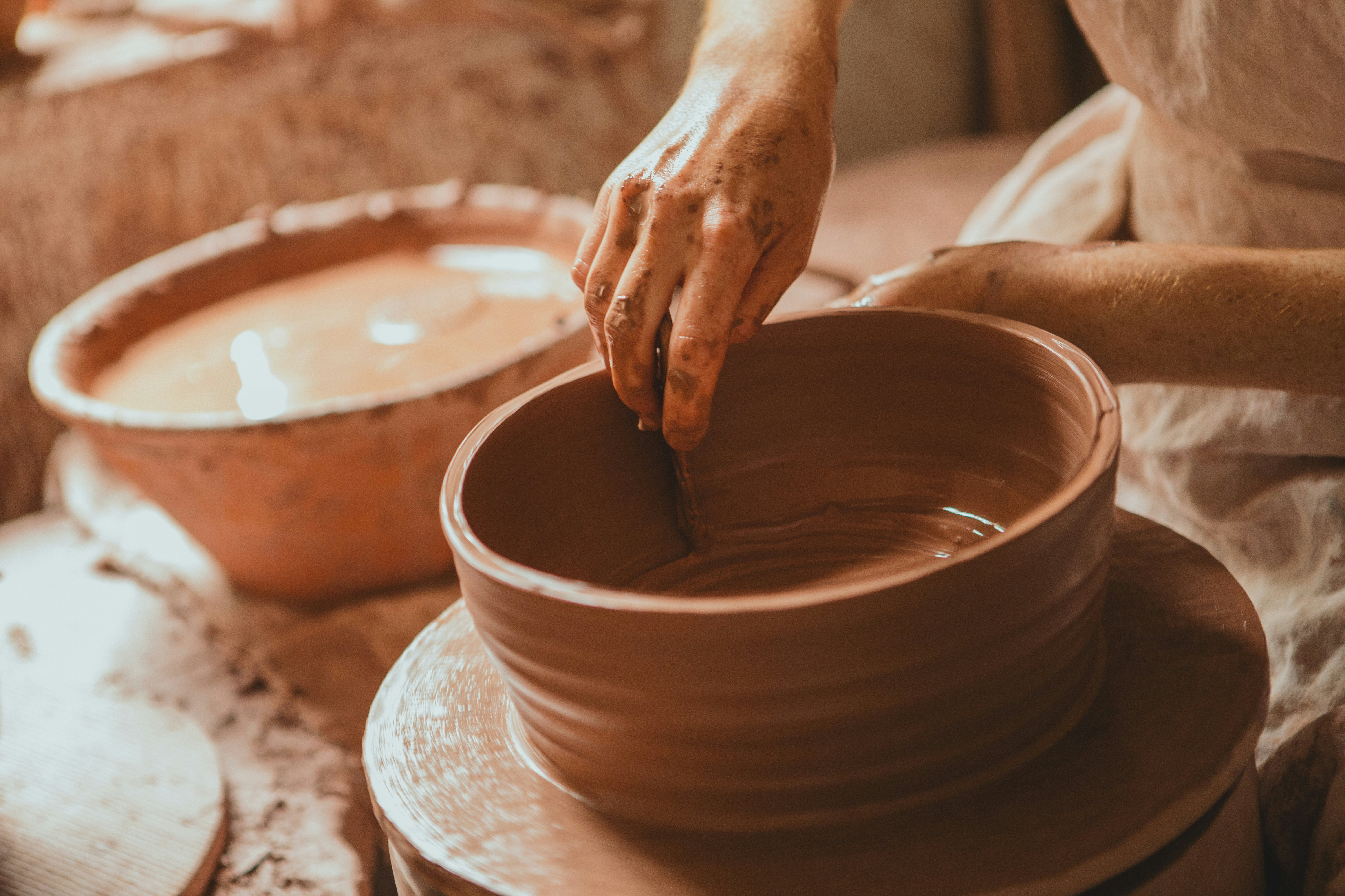 Woman sculpting clay on a spinning wheel at Old Salem Museums & Gardens. Old Salem Museums & Gardens, located in Winston-Salem, is one of the nation's shining examples of living history dating back to the 18th century.