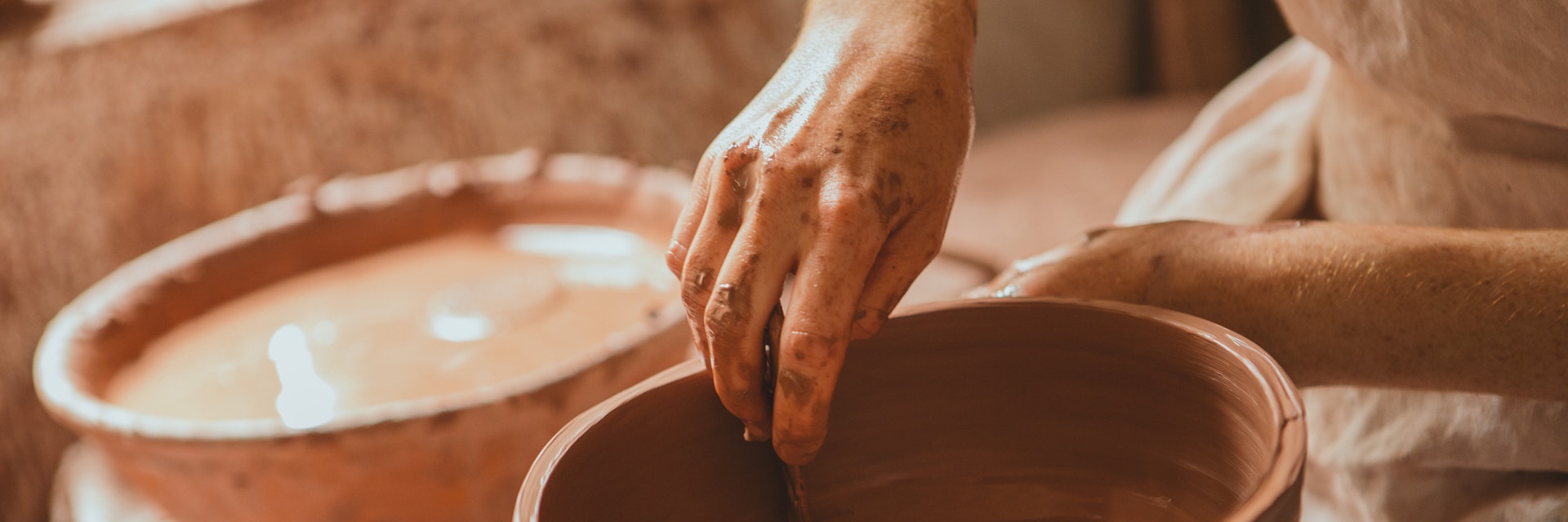 Woman sculpting clay on a spinning wheel at Old Salem Museums & Gardens. Old Salem Museums & Gardens, located in Winston-Salem, is one of the nation's shining examples of living history dating back to the 18th century.