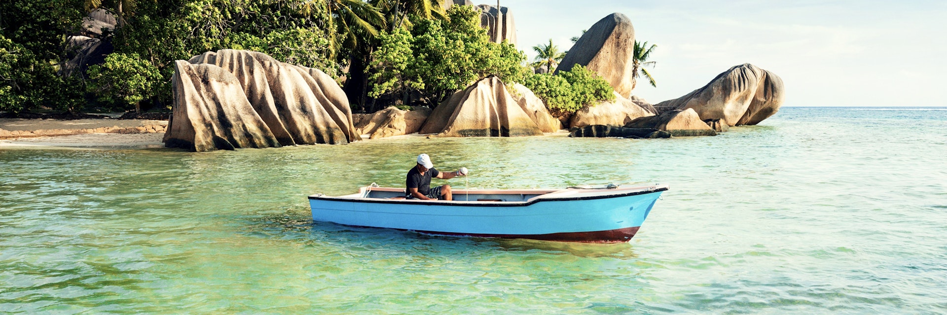 Man fishing off Anse Source d’Argent beach.