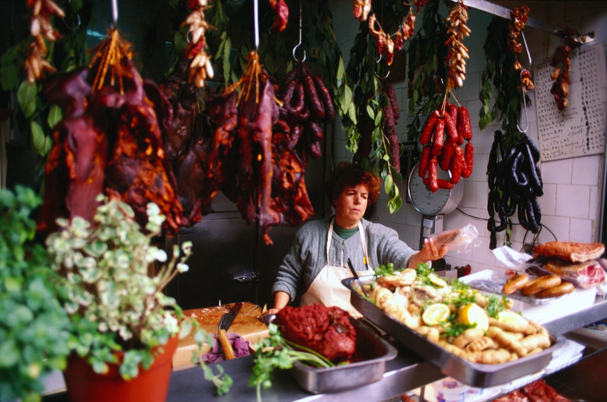 Trader at meat goods stall at Bolhao Market.