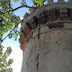 Spanish colonial era tower with battlements and multiple bullet holes, National Museum of Costa Rica.