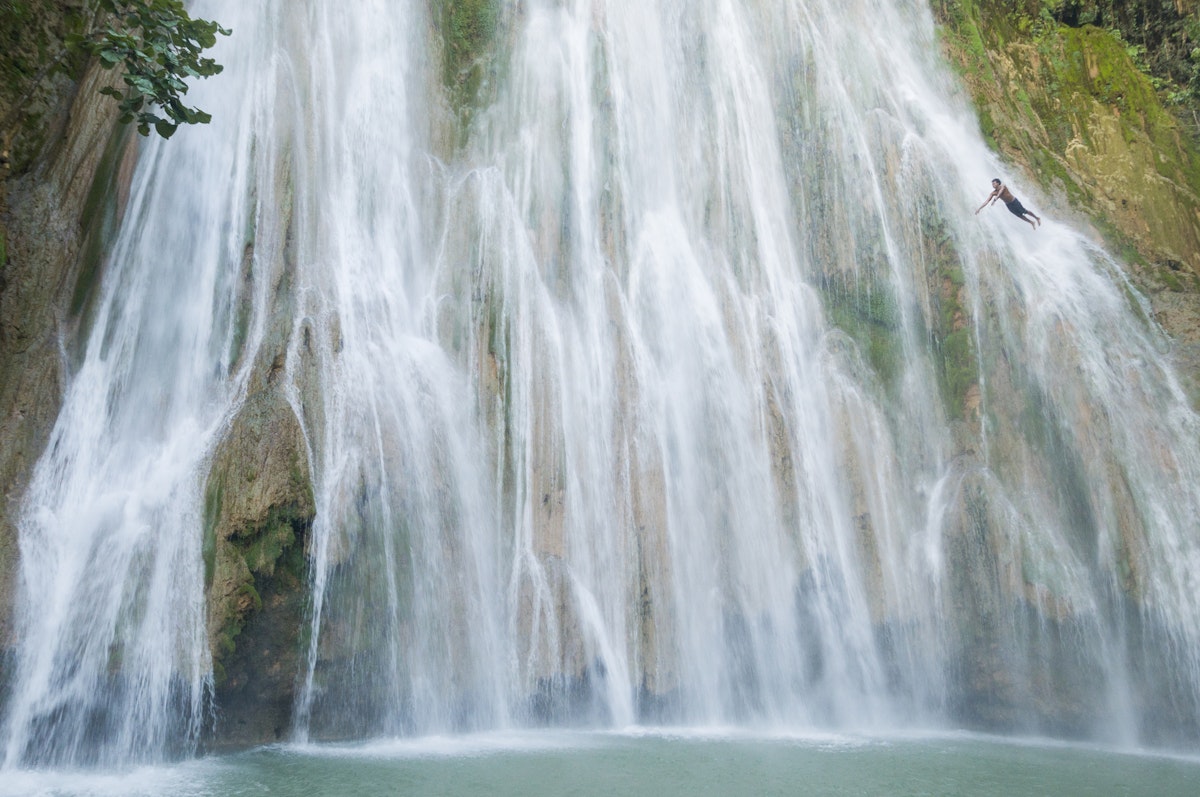 A young man diving off El Limon, the waterfall at Samana, Dominican Republic