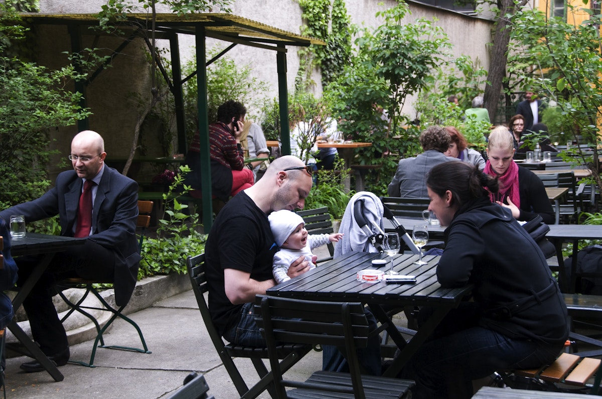 People in garden courtyard of Weinstube Josefstadt Cafe.