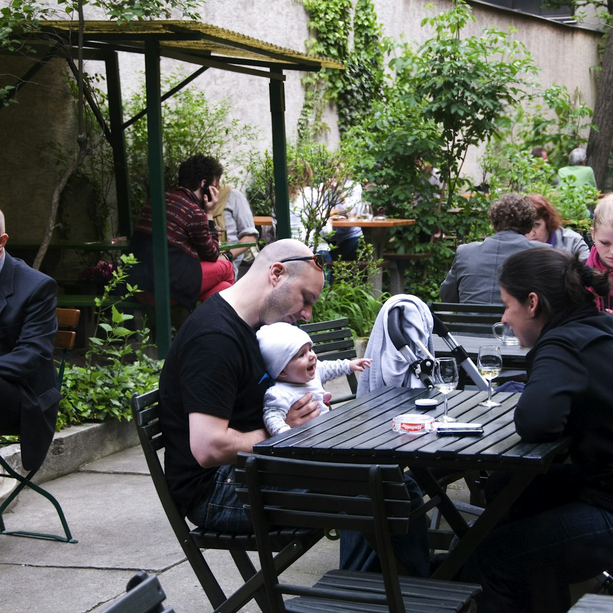 People in garden courtyard of Weinstube Josefstadt Cafe.