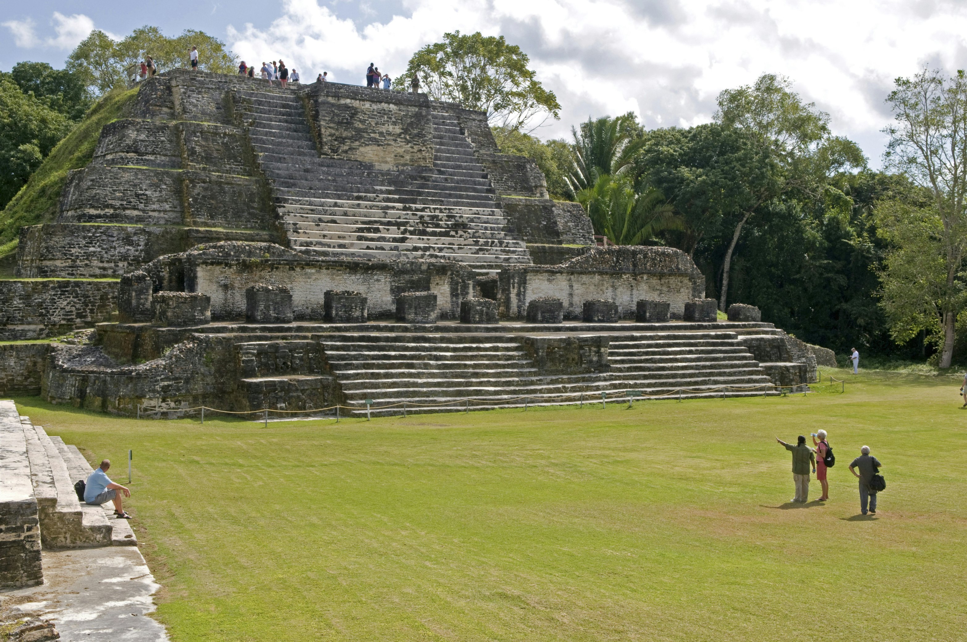 Belize, Belize District, Altun Ha, Tourists in front and on top of the Temple of Masonry Altars in Plaza B of the Mayan ruins A large carved jade head of the Mayan sun god Kinich Ahau was found in the temple.