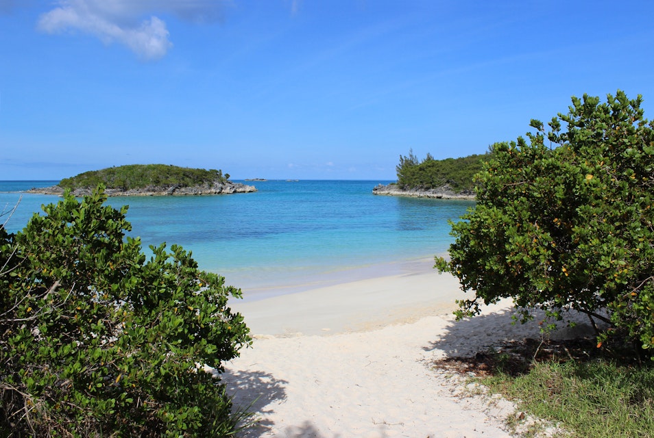 Pretty view of Turtle Bay Beach on the island of Bermuda in the Caribbean.  The photo shows the beautiful pink sand beach and calm blue green coloured water with islands out in front.  The beach is on Cooper's Island conservation area, near Clearwater Beach.