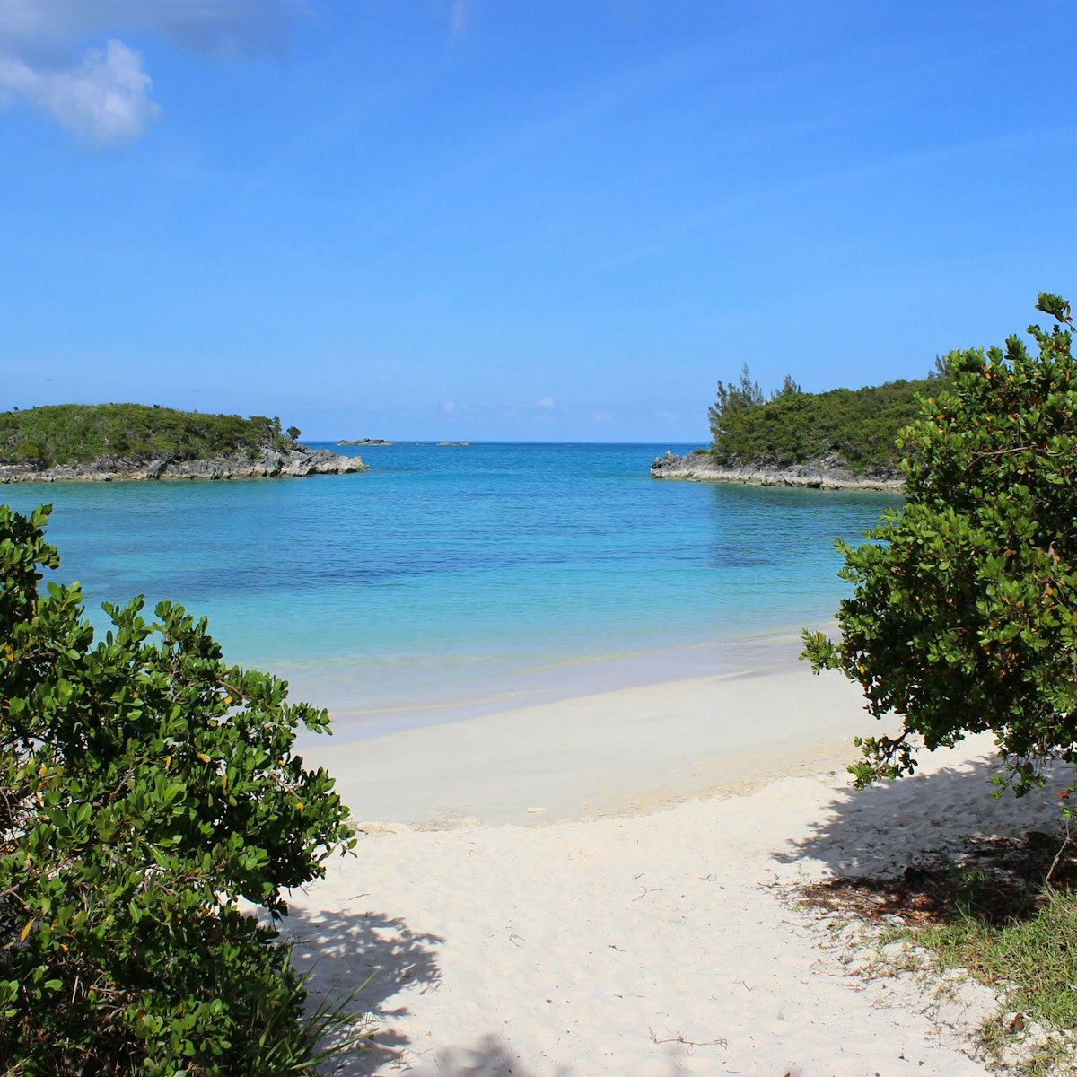 Pretty view of Turtle Bay Beach on the island of Bermuda in the Caribbean.  The photo shows the beautiful pink sand beach and calm blue green coloured water with islands out in front.  The beach is on Cooper's Island conservation area, near Clearwater Beach.
