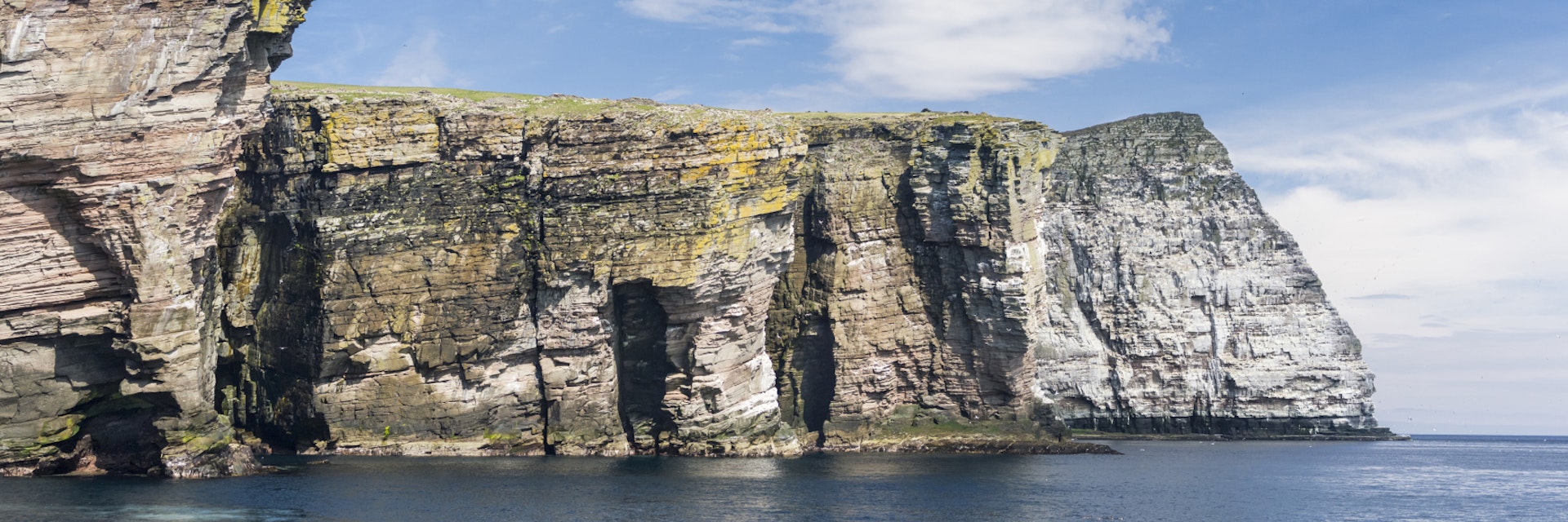 In geography and geology, a cliff is a vertical, or near vertical, rock exposure. Cliffs are formed as erosion landforms due to the processes of erosion and weathering that produce them. Cliffs are common on coasts, in mountainous areas, escarpments and along rivers. Cliffs are usually formed by rock that is resistant to erosion and weathering. Sedimentary rocks most likely to form cliffs include sandstone, limestone, chalk, and dolomite. Igneous rocks such as granite and basalt also often form cliffs.