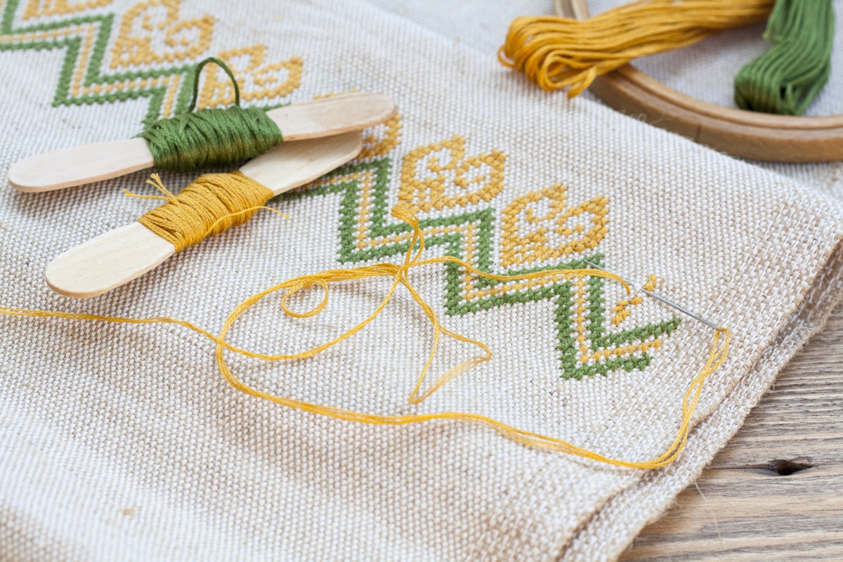 500px Photo ID: 125765923 - Ukrainian embroidery on the linen fabric and thread embroidery on a wooden table, selective focus