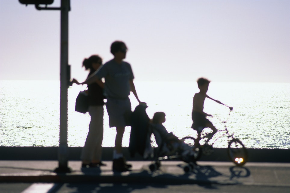 A family takes an early evening stroll along Redondo Beach in Los Angeles.