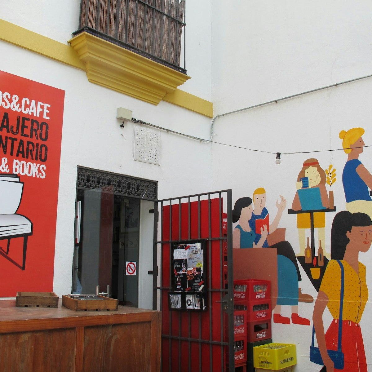Door with sign and paintings on wall, El Viajero Sedentario coffee and books cafe.