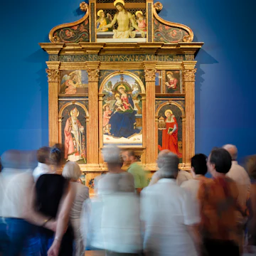 Tourist admire Pintoricchio's Pala di Santa Maria dei Fossi(1495) in the National Gallery of Umbria.(Galleria Nazionale dell'Umbria). In the center of the multipaneled painting, the Madonna holds baby Jesus on her lap and a Pomergrante in the other hand.