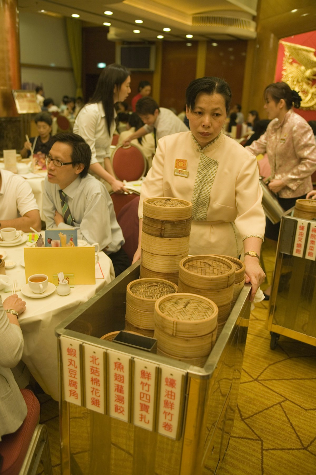 Woman serving dim sum at Maxim's Palace City Hall Restaurant.