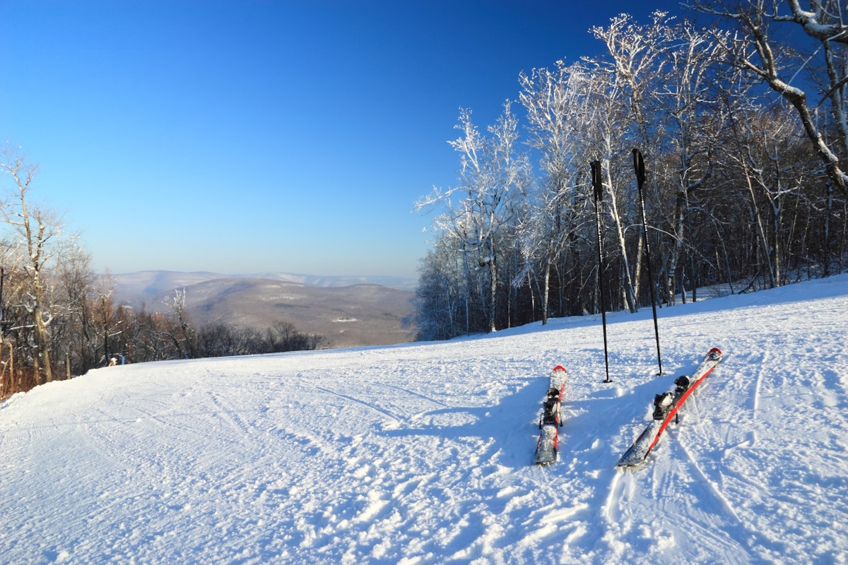 Snow clad skis and poles at the top of a ski trail at Belleayre Mountain Ski Resort in the Catskills Mountains of New York