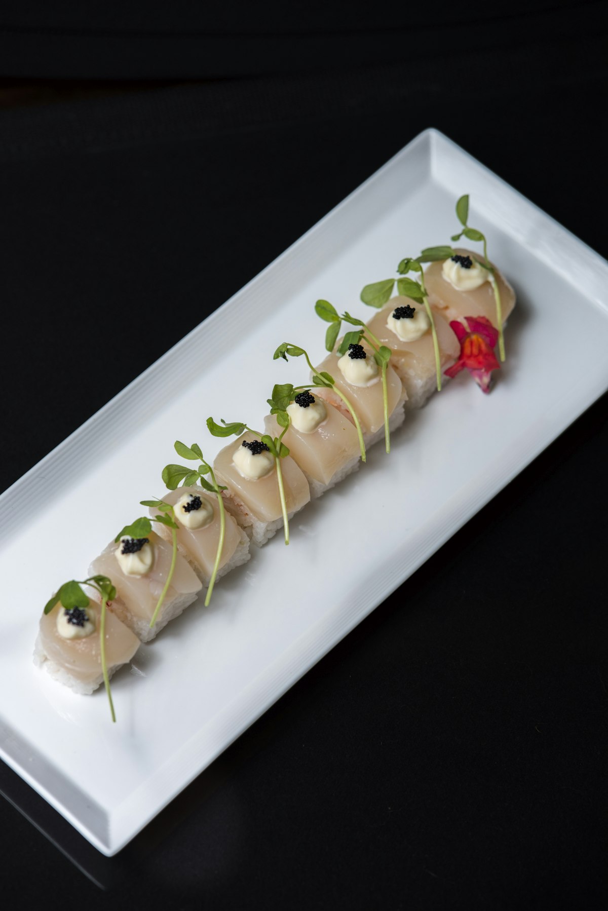 Scallop roll with black tobiko caviar, mayonnaise and sprouts.