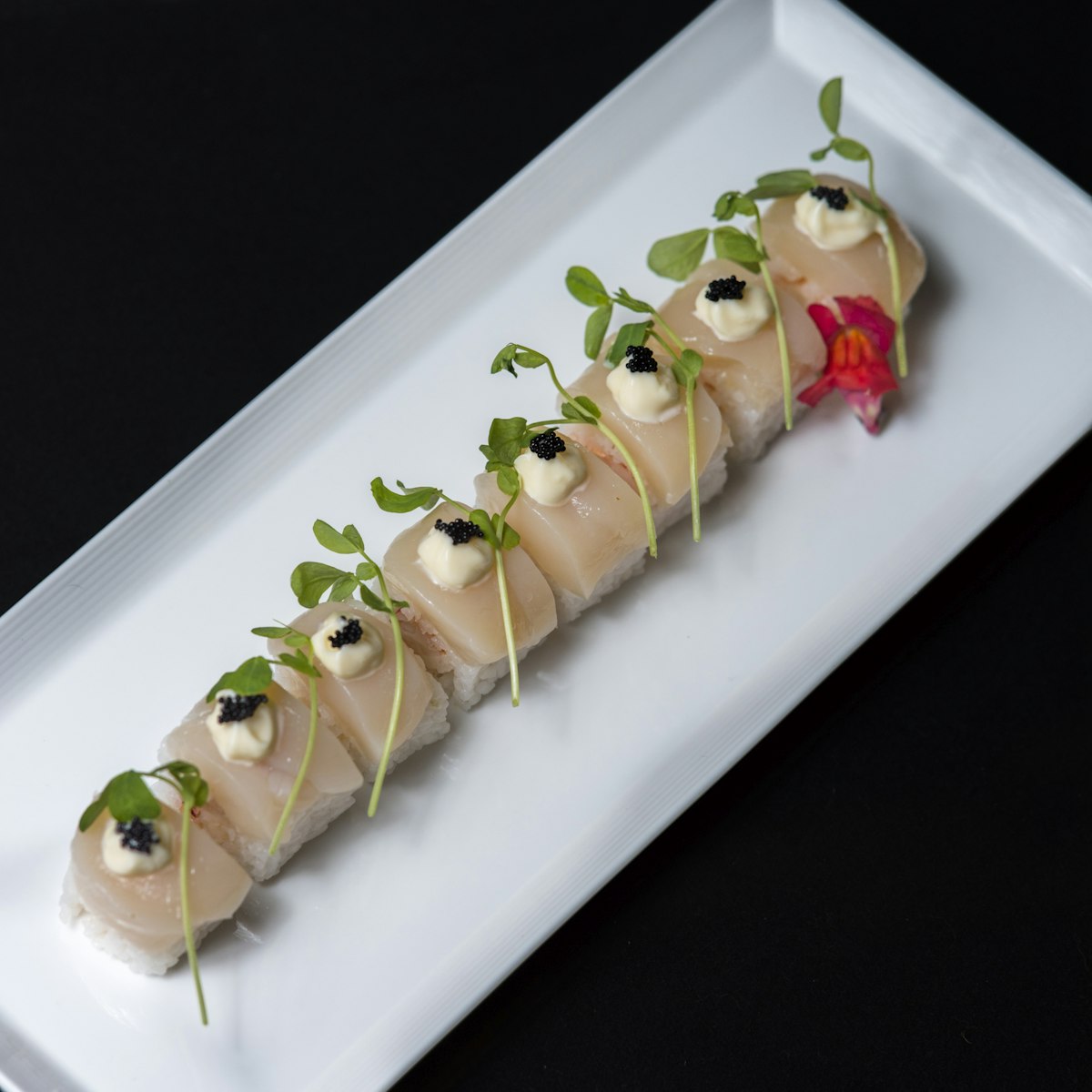 Scallop roll with black tobiko caviar, mayonnaise and sprouts.