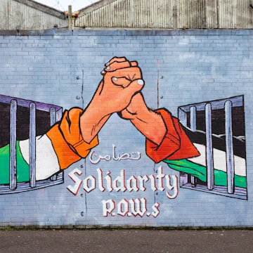 BELFAST, NORTHERN IRELAND - FEB 9, 2014: Political mural in Belfast, Northern Ireland. Falls Road is famous for its political murals. ; Shutterstock ID 191463122; Your name (First / Last): Lauren Gillmore; GL account no.: 56530; Netsuite department name: Online-Design; Full Product or Project name including edition: 65050/ Online Design /LaurenGillmore/IFY