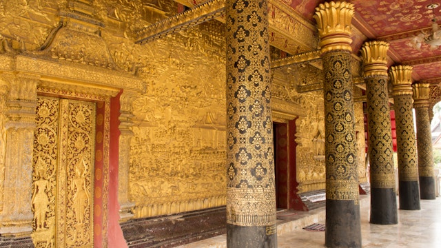 This image shows a Wat detail, door, wall, pole,  in  wat mai  (Luang Prabang, Laos)