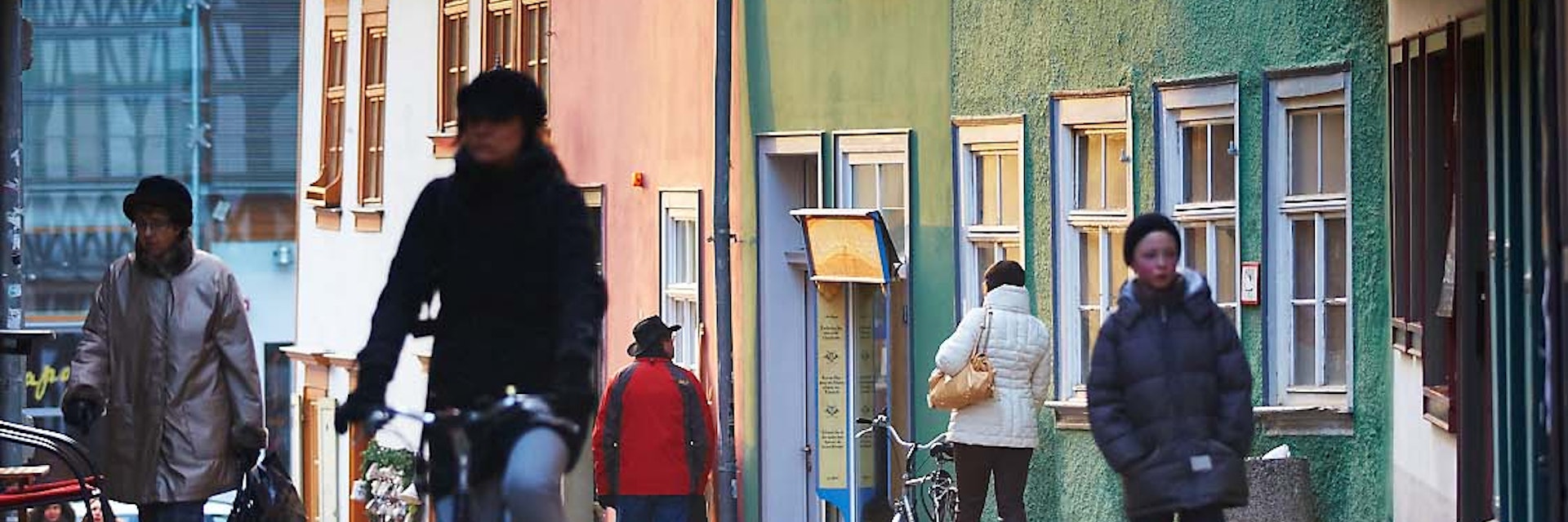 Cyclist riding down cobbled street.