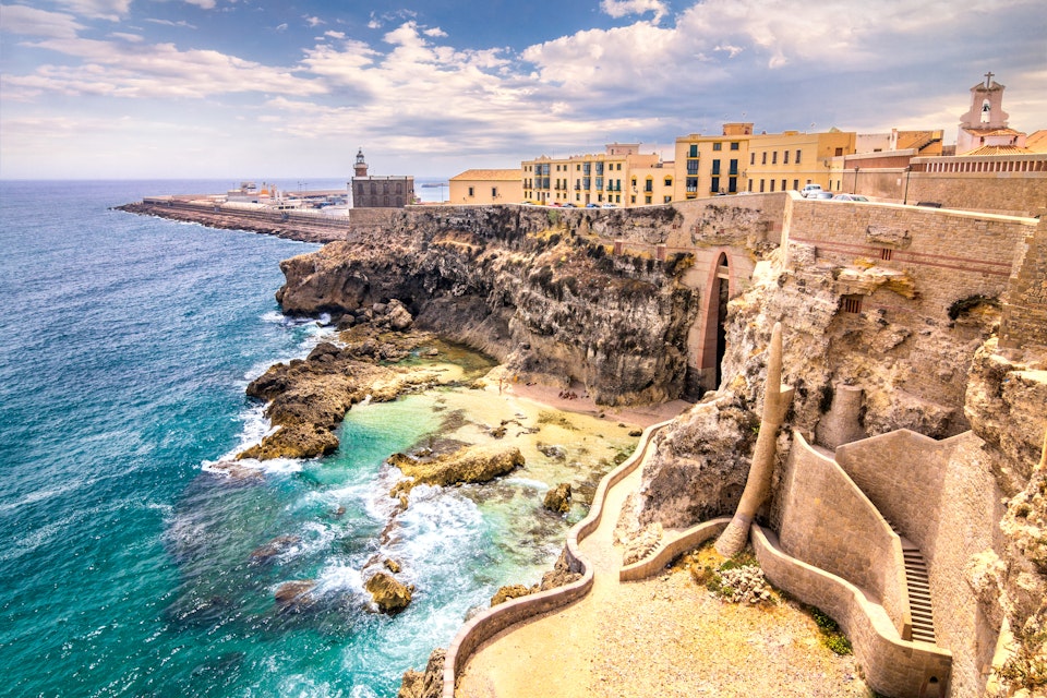 City walls, lighthouse and harbor in Melilla, Spanish province in Morocco. The rocky coast of the Mediterranean Sea.; Shutterstock ID 589530758; Your name (First / Last): Lauren Keith; GL account no.: 65050; Netsuite department name: Online Editorial; Full Product or Project name including edition: Destination page image update