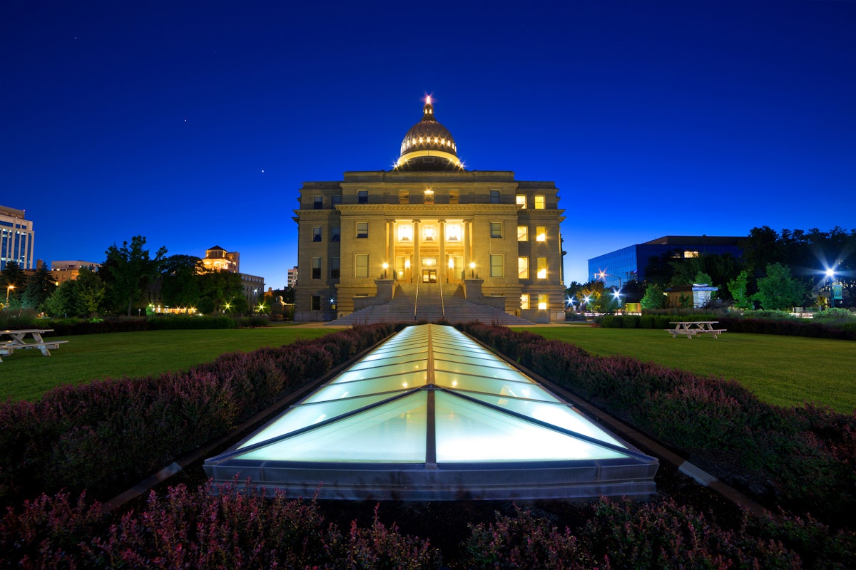 Idaho state capitol building at dusk, wide low angle view with ground-level skylight illuminated.