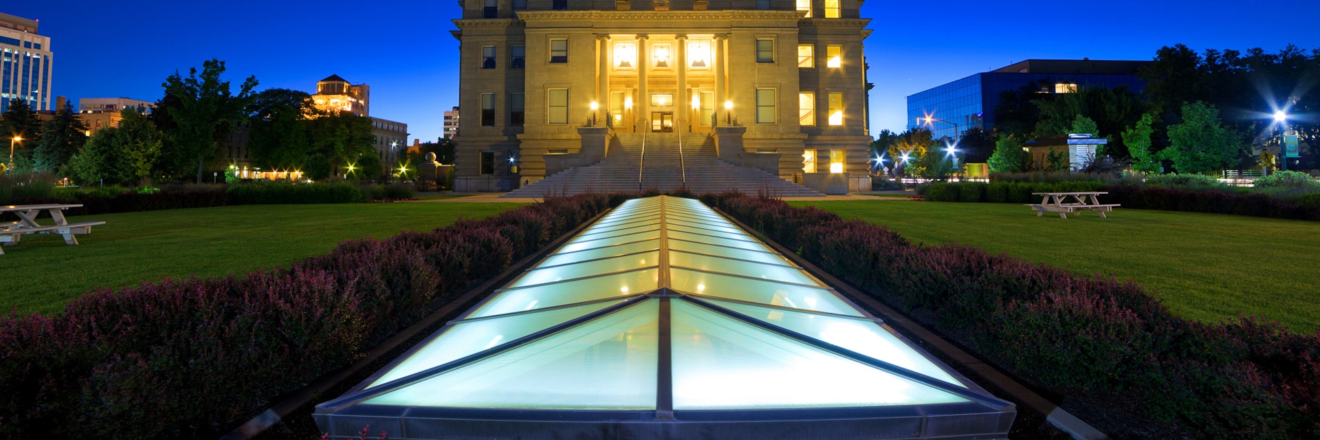 Idaho state capitol building at dusk, wide low angle view with ground-level skylight illuminated.