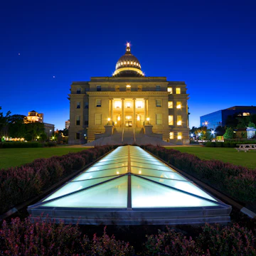 Idaho state capitol building at dusk, wide low angle view with ground-level skylight illuminated.