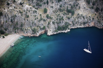 Aerial of yacht and cliff face at Butterfly Valley.
