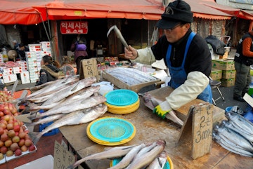 Gyongdong Market, man preparing salted fish.