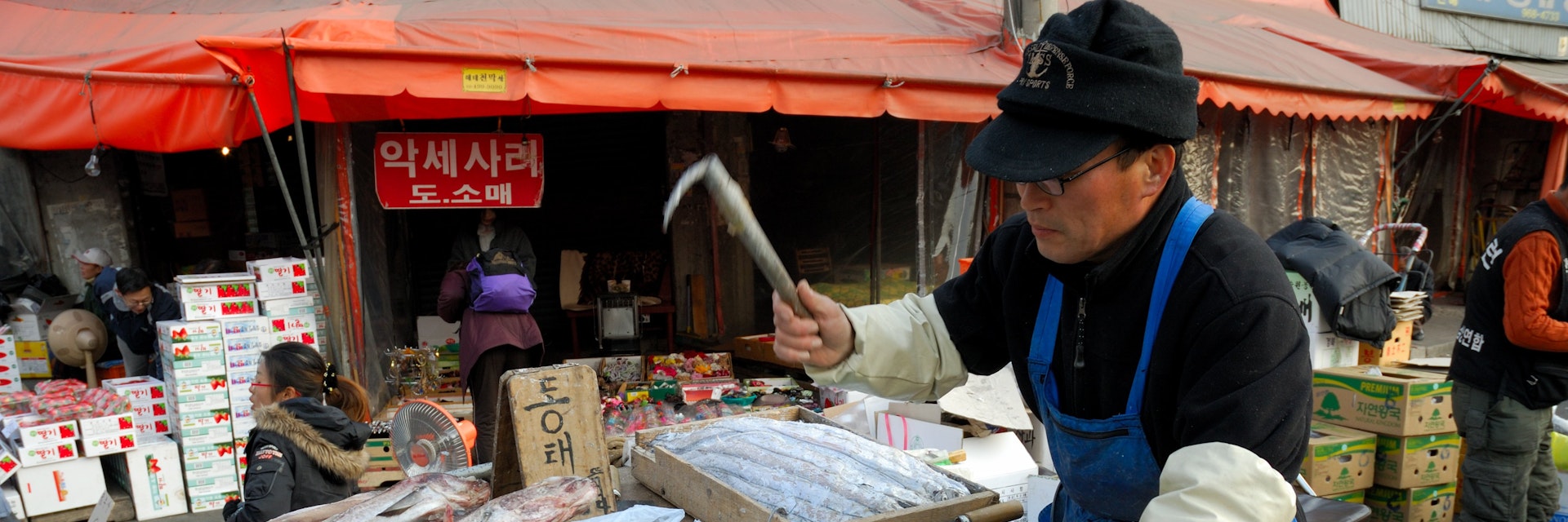 Gyongdong Market, man preparing salted fish.