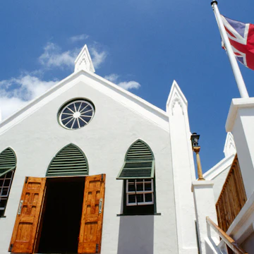 bermuda, st george s island, st. georges, st peters church facade with open door and windows, british union jack flag flying outside.
