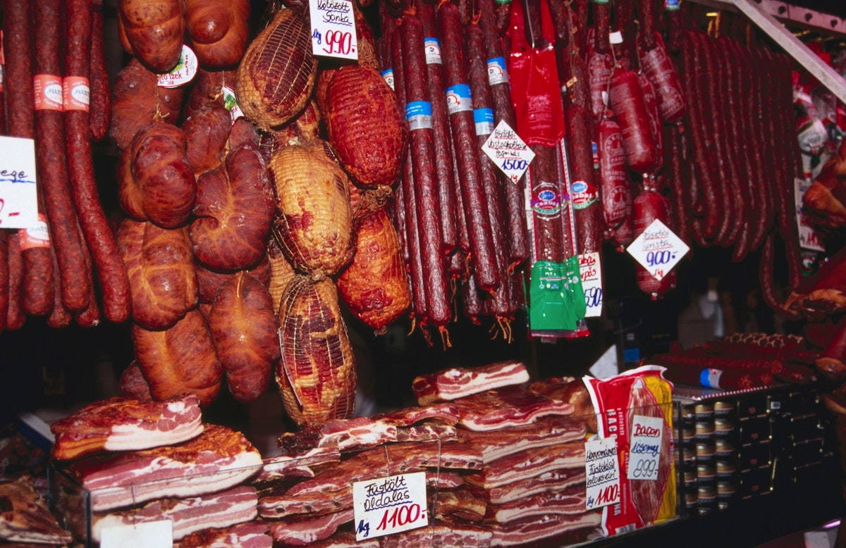Smoked sausage meat hanging at food stall at Nagycsarnok Market.