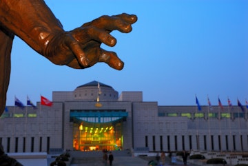 Hand of statue in front of War Memorial at dusk.