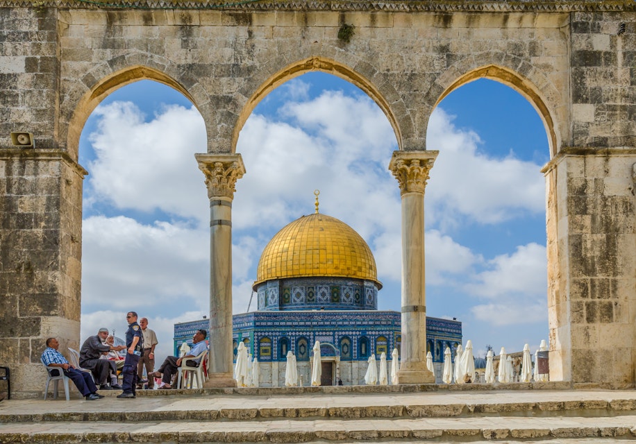 JERUSALEM, ISRAEL JUNE 10 2015: Israeli Temple Mount policeman greets the locals under the arches near the Dome of the Rock on the Temple Mount on June 10 2015 in the Old City of Jerusalem Israel.; Shutterstock ID 408810679; Your name (First / Last): Lauren Keith; GL account no.: 65050; Netsuite department name: Online Editorial; Full Product or Project name including edition: Middle East Online Highlights Update
