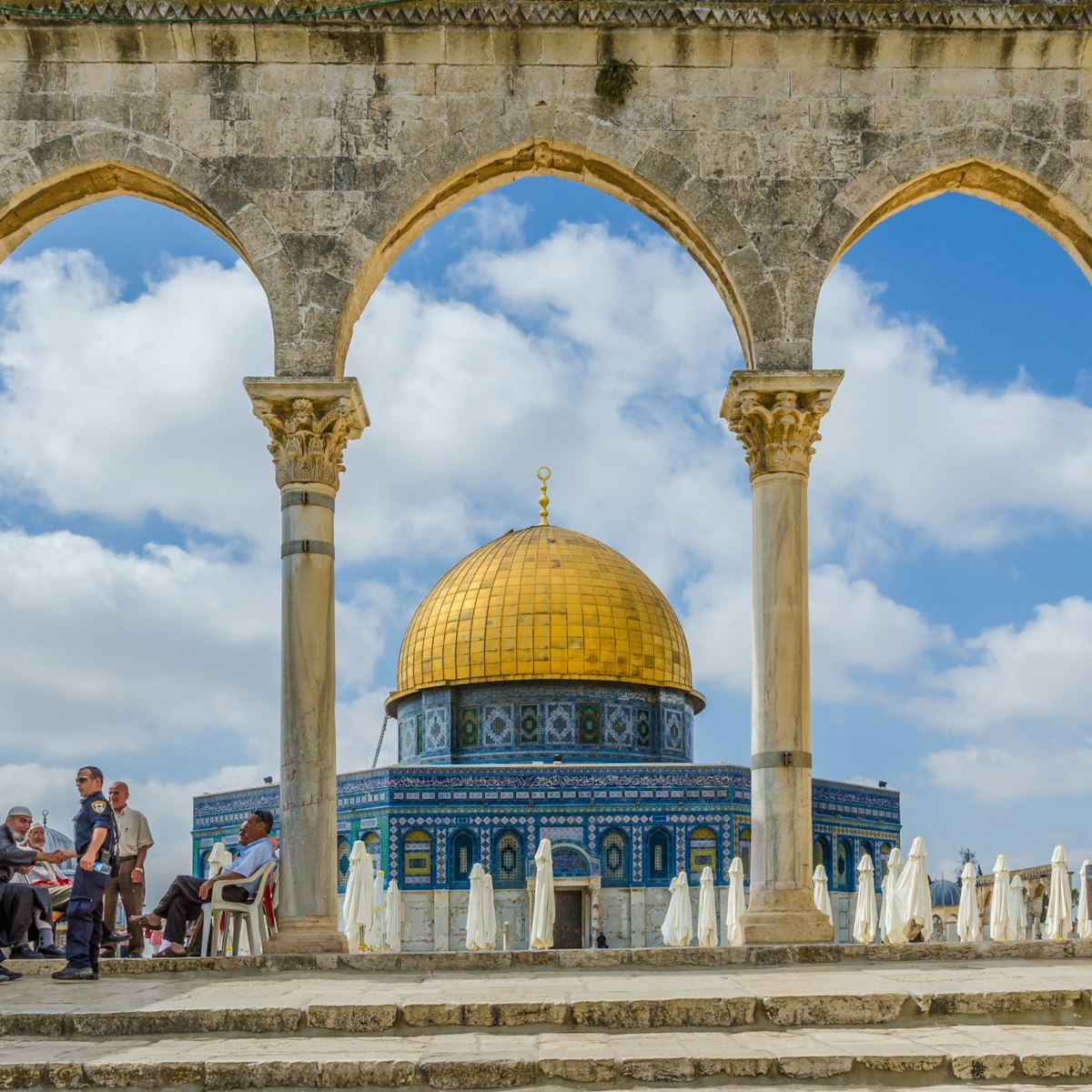 JERUSALEM, ISRAEL JUNE 10 2015: Israeli Temple Mount policeman greets the locals under the arches near the Dome of the Rock on the Temple Mount on June 10 2015 in the Old City of Jerusalem Israel.; Shutterstock ID 408810679; Your name (First / Last): Lauren Keith; GL account no.: 65050; Netsuite department name: Online Editorial; Full Product or Project name including edition: Middle East Online Highlights Update