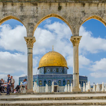 JERUSALEM, ISRAEL JUNE 10 2015: Israeli Temple Mount policeman greets the locals under the arches near the Dome of the Rock on the Temple Mount on June 10 2015 in the Old City of Jerusalem Israel.; Shutterstock ID 408810679; Your name (First / Last): Lauren Keith; GL account no.: 65050; Netsuite department name: Online Editorial; Full Product or Project name including edition: Middle East Online Highlights Update